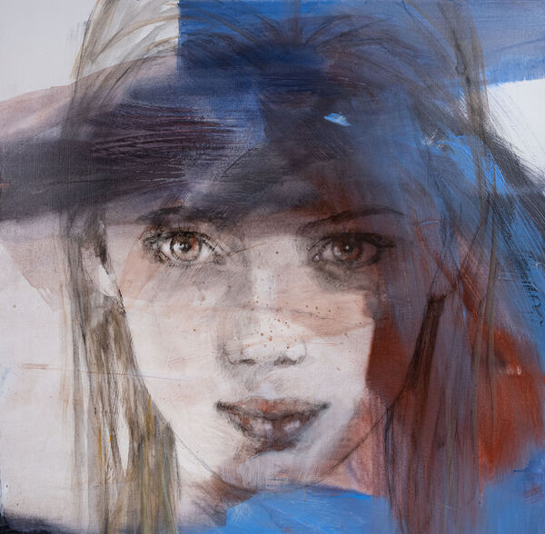 Groot portret van een jonge vrouw met blauwe verfstrepen over het gezicht, bruine ogen en sproeten